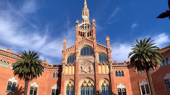 圣保罗医院的入口，巴塞罗那现代主义建筑的杰作。攀爬到塔尖上，塔尖两侧是棕榈树。