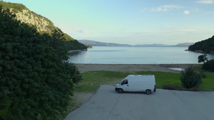 一辆露营车的无人机鸟瞰图，独自在希腊马拉西亚的野生海滩上