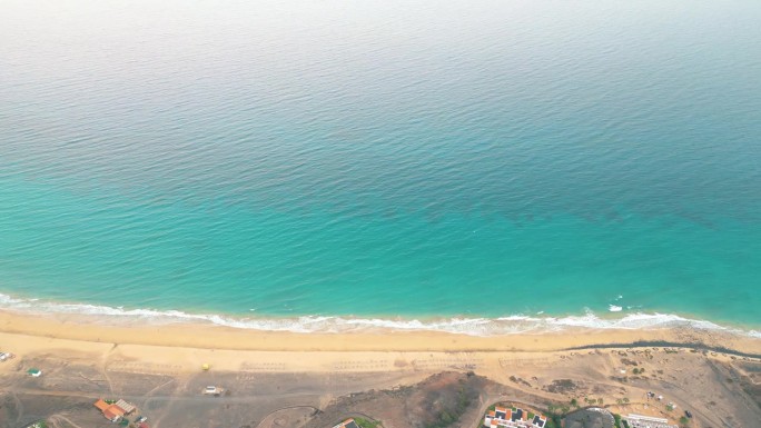 夏天的海景美丽的波浪，蓝色的海水在阳光明媚的日子。西班牙，加那利岛，埃斯昆佐海滩。海上鸟瞰图，热带自