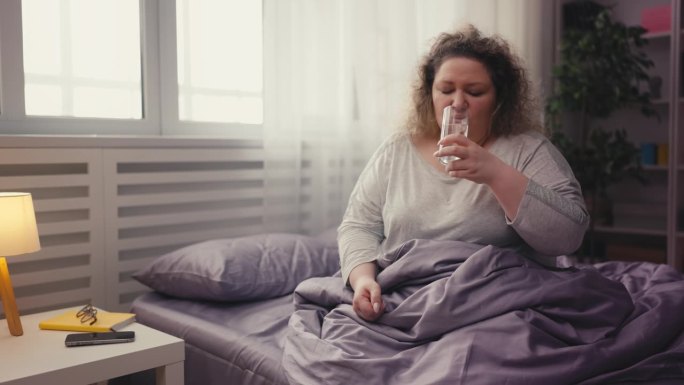 肥胖中年女性服用止痛药，多喝水，健康