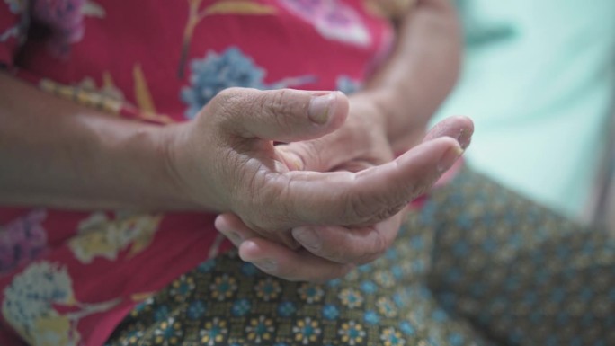 老年妇女按摩手:健康与衰老的概念