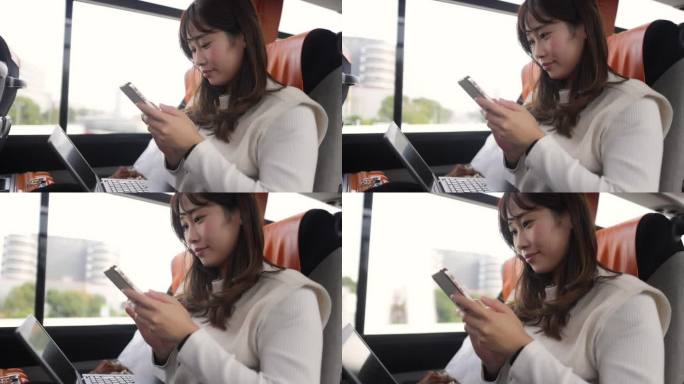 女商人在机场巴士上使用智能手机和笔记本电脑