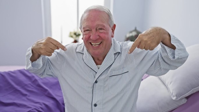 兴高采烈的老人坐在床上，用手指着自己，脸上带着骄傲的表情。在卧室里穿着睡衣，看起来很自信，笑得很开心