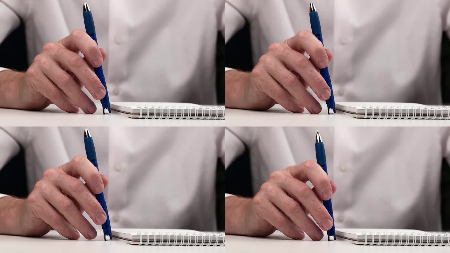 用圆珠笔敲打桌面特写。男人若有所思地敲了敲笔记本旁边的桌子上的笔。