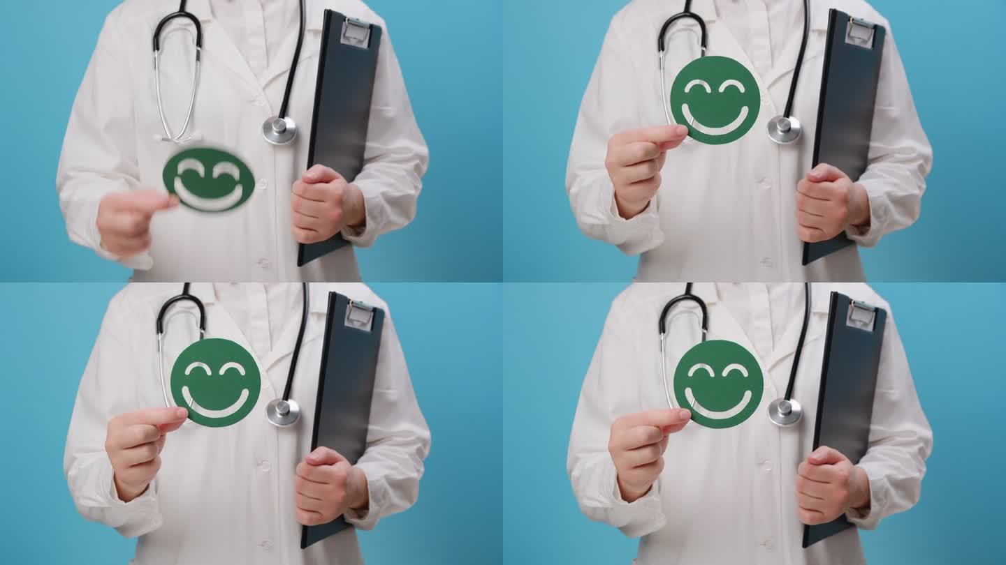 年轻女医生的特写，穿着白色制服，听诊器拿着绿色的快乐笑脸，孤立在蓝色背景上，满意度调查，儿童健康，世