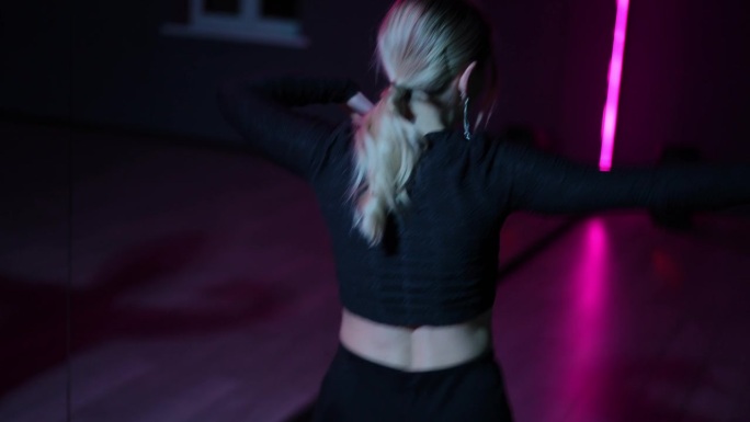 住相机。跳舞的女人。在霓虹灯大厅里表演Waacking舞蹈时，手臂挥动和手势的特写。