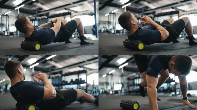 肌肉发达的男运动员穿着运动服在健身房做泡沫滚轮练习以缓解背部疼痛
