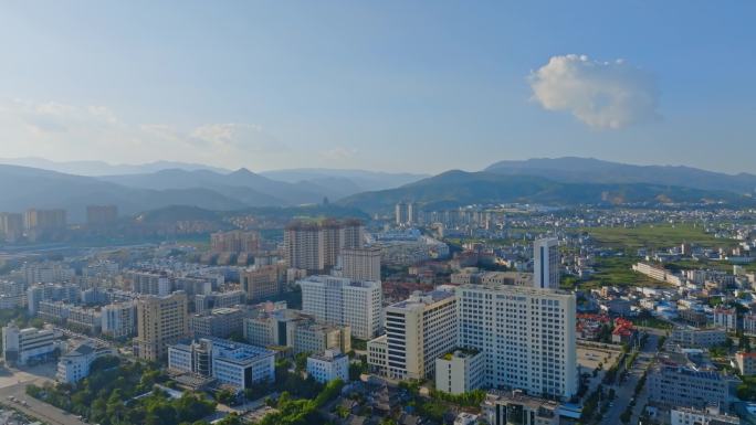 傍晚时分夕阳照耀下的大理祥云城市逆光航拍