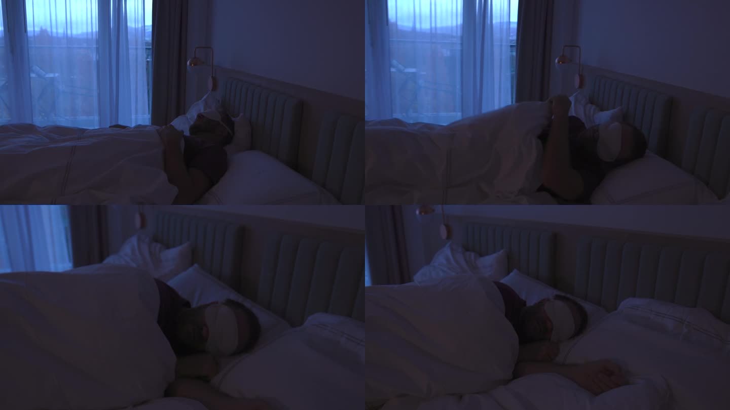戴着眼罩在床上睡不着的男人