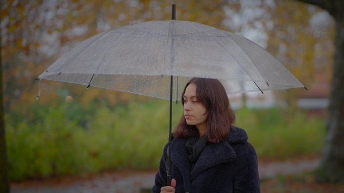 在阴沉的雨天，疑神疑鬼的女性拿着雨伞