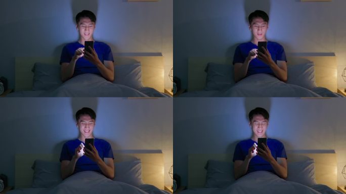 男子滚动智能手机黑暗