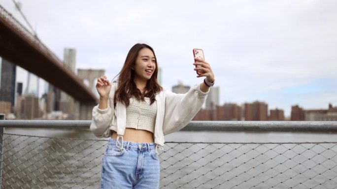 中国女孩游览纽约，在布鲁克林大桥下自拍