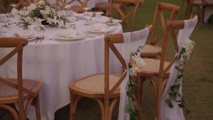 节日精美摆设餐桌排椅鲜花接待婚宴。