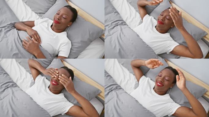 一个非裔美国妇女躺在床上，双手蒙住眼睛，笑得欢快而有趣。盲目的概念。在卧室