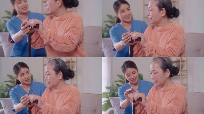 一位富有同情心的年轻亚洲女护士在家中客厅用拐杖帮助一位年长的亚洲女士从沙发上站起来。护士提供有力的支
