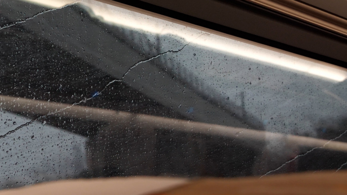 车窗外下雨雨痕划过窗户玻璃