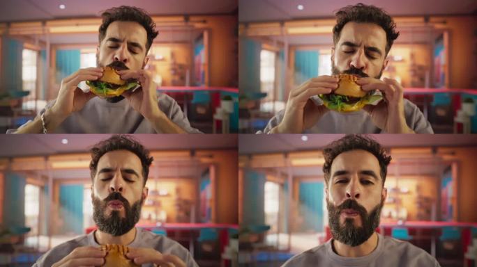 跟踪一个正在家里享受美味汉堡的男人的慢动作肖像。一个快乐的男人点了快餐，五彩缤纷的环境，高品质的认可