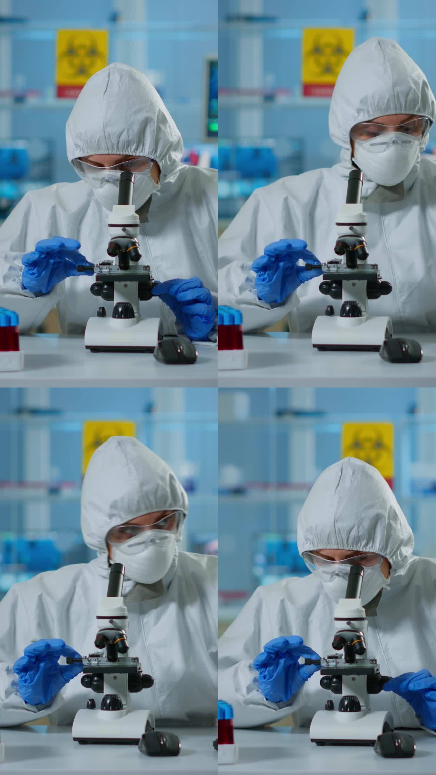 垂直视频:穿着防护服的科学家进行调整，并通过实验室显微镜观察