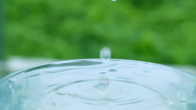 水滴落在装满水的杯子里，溢出来，也象征着生命的给予和富足。