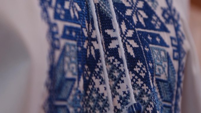 一件衬衫上的蓝色刺绣装饰，乌克兰民族服装的特写图，象征乌克兰。刺绣十字绣。乌克兰民族针法。传统的服装