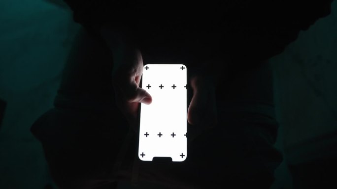 俯视图，一个男人在黑暗中上厕所，在智能手机屏幕上滚动，屏幕上有一个空白的空白空间供插入。他站起来，穿