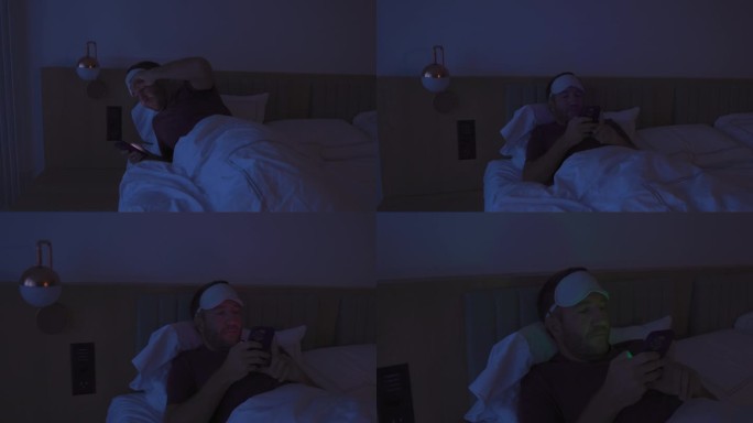 夜间难以入睡的男性在床上使用手机，睡眠障碍和失眠