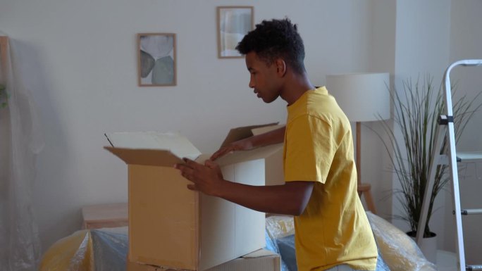 年轻的非裔美国人搬到新家，带着纸板箱