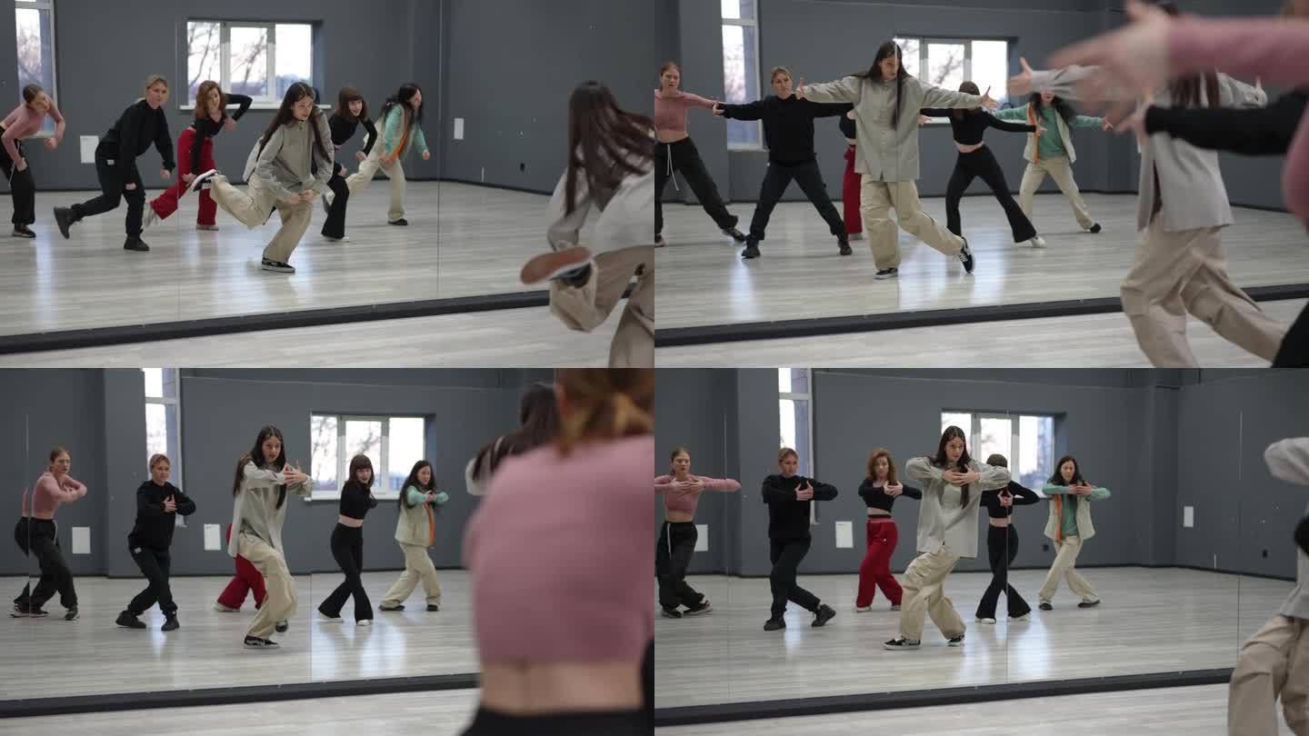 女孩跳舞。小组练习。五名舞者跟随体育舞蹈老师重复嘻哈元素。