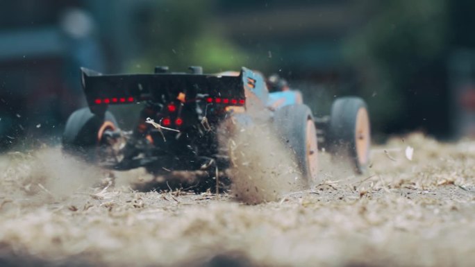 无线电控制的汽车模型漂移在沙质道路上的比赛，使大量的灰尘，慢动作的电影镜头