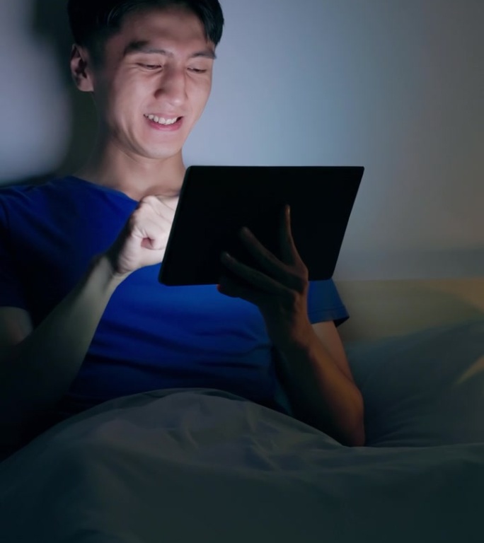 男子滚动平板电脑黑暗