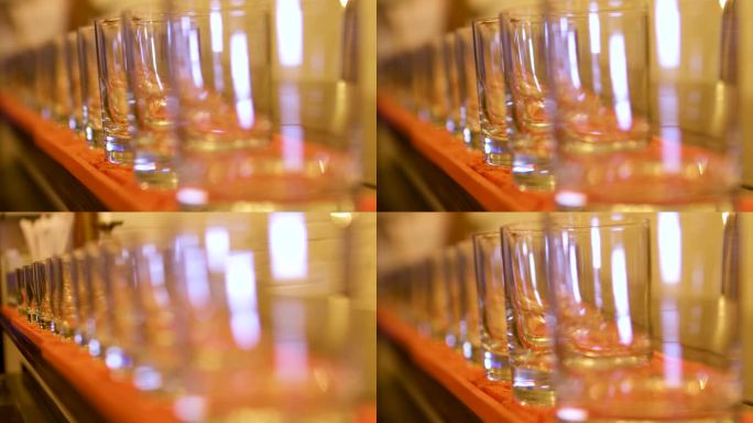 空玻璃玻璃杯站在一条线上改变焦点从第一到最后美丽的背景模糊橙色桌游戏与锐利庆祝餐厅酒吧柜台