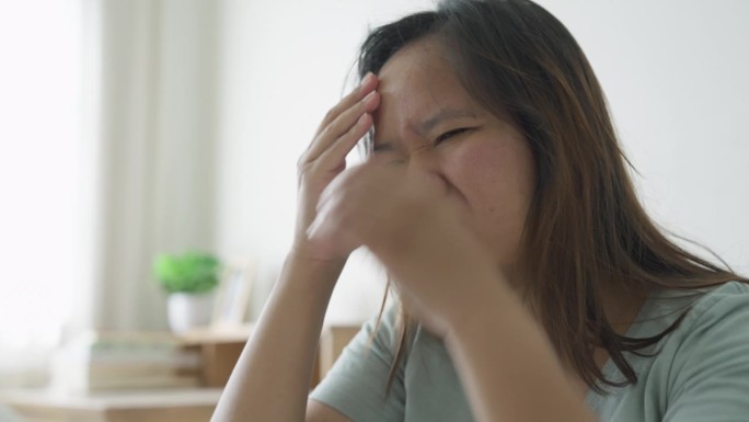 早上醒来后头痛的女人坐在床上