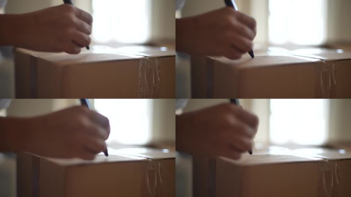 特写镜头，一位不知名的非裔美国年轻女性正坐在那里，在纸板箱上写着搬到新房子的标签。新生活理念