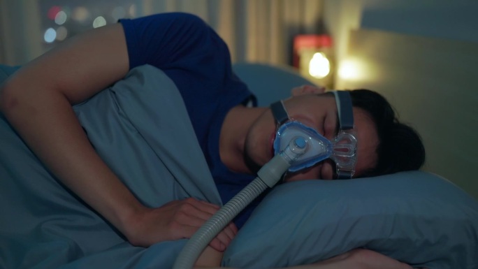 男人带着呼吸机睡觉