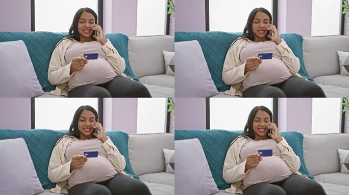年轻的孕妇拿着信用卡坐在家里的沙发上讲手机