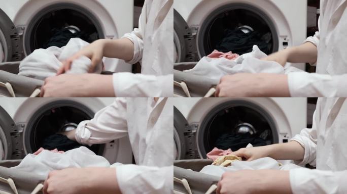 一个女人从洗衣机里拿出湿衣服