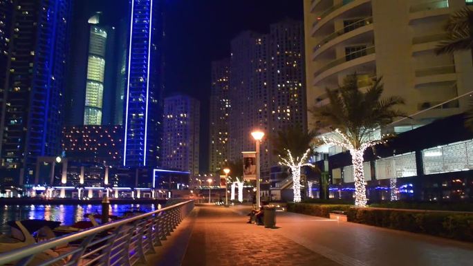 2016年12月5日，阿联酋迪拜:在摩天大楼的灯光下，沿着迪拜码头漫步
