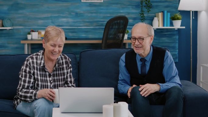 快乐的老夫妇用笔记本电脑和侄子视频通话