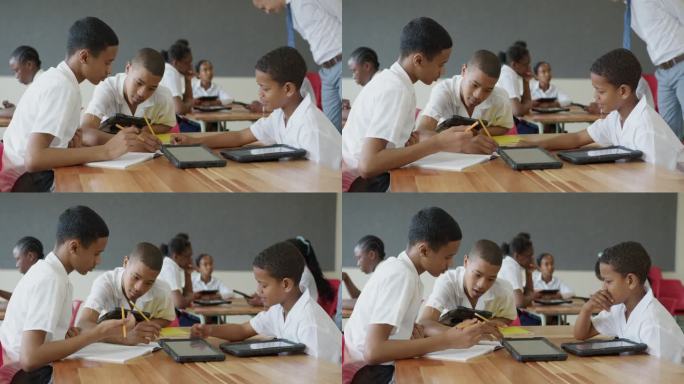 男生们一起用平板电脑和练习本做数学题