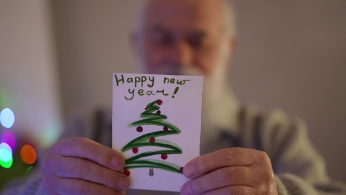 一位白发苍苍的老人在读新年贺卡。