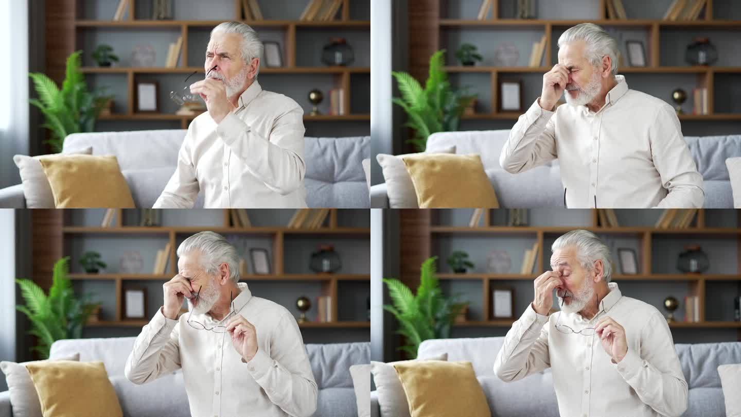 一位白发老人坐在家里客厅的沙发上，眼睛疲劳