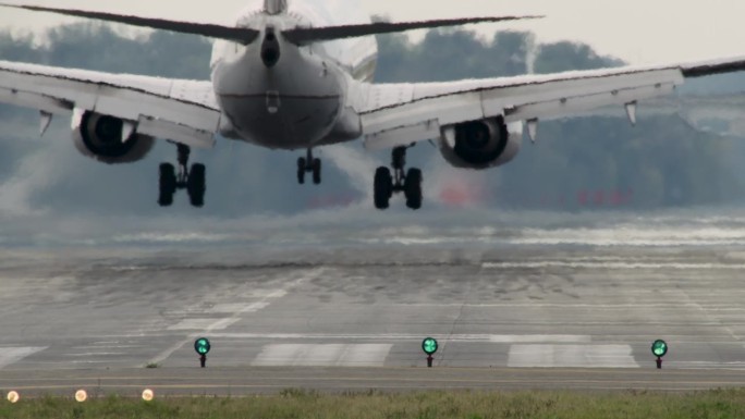 飞机降落在停机坪上，轮胎冒出一股浓烟