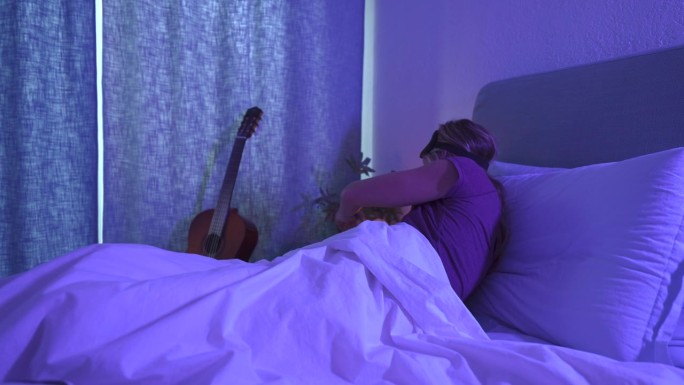 躺在床上睡不着的女人用手机，她睡不着
