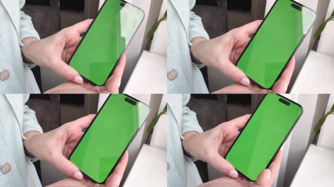 一个小女孩的手拿着一个绿色屏幕的智能手机，向镜头近距离展示