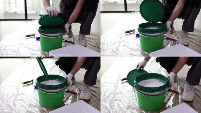 修理工大师用白色油漆打开塑料罐，特写4k电影慢动作