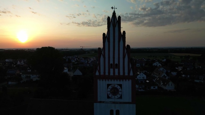 照亮教堂尖塔和时钟的黄金时刻背景。空中,视差