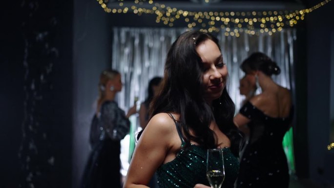 性感的黑发美女的肖像与一杯香槟在圣诞派对上跳舞