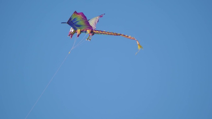 龙风筝在晴朗的蓝天上，尾巴在4k