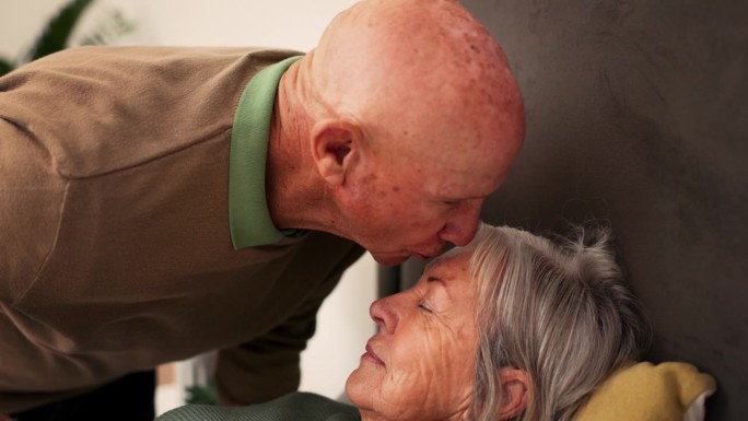 床上，亲吻额头和长辈夫妇的支持，联系和同情在家里康复。退休、结婚和年老的男人照顾生病的女人，在卧室里