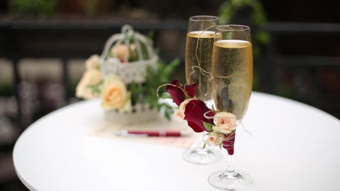 优雅的婚礼餐桌设置香槟长笛，装饰鸟笼插花，书法笔，邀请卡。婚礼浪漫庆典装饰。节日优雅的招待会。